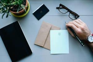 A Desk With An Envelope And A Pen On Top